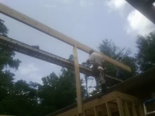 Carpenter setting a ridge beam over a new addition frame — Ice Dam Removal by Roofing Brothers in Santo Domingo Pueblo
