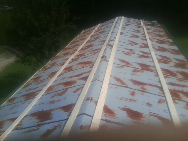 Rusted metal roof panels with new wood purlins before replacement — Storm Damage Roof Repair in Santo Domingo Pueblo by Roofing Brothers