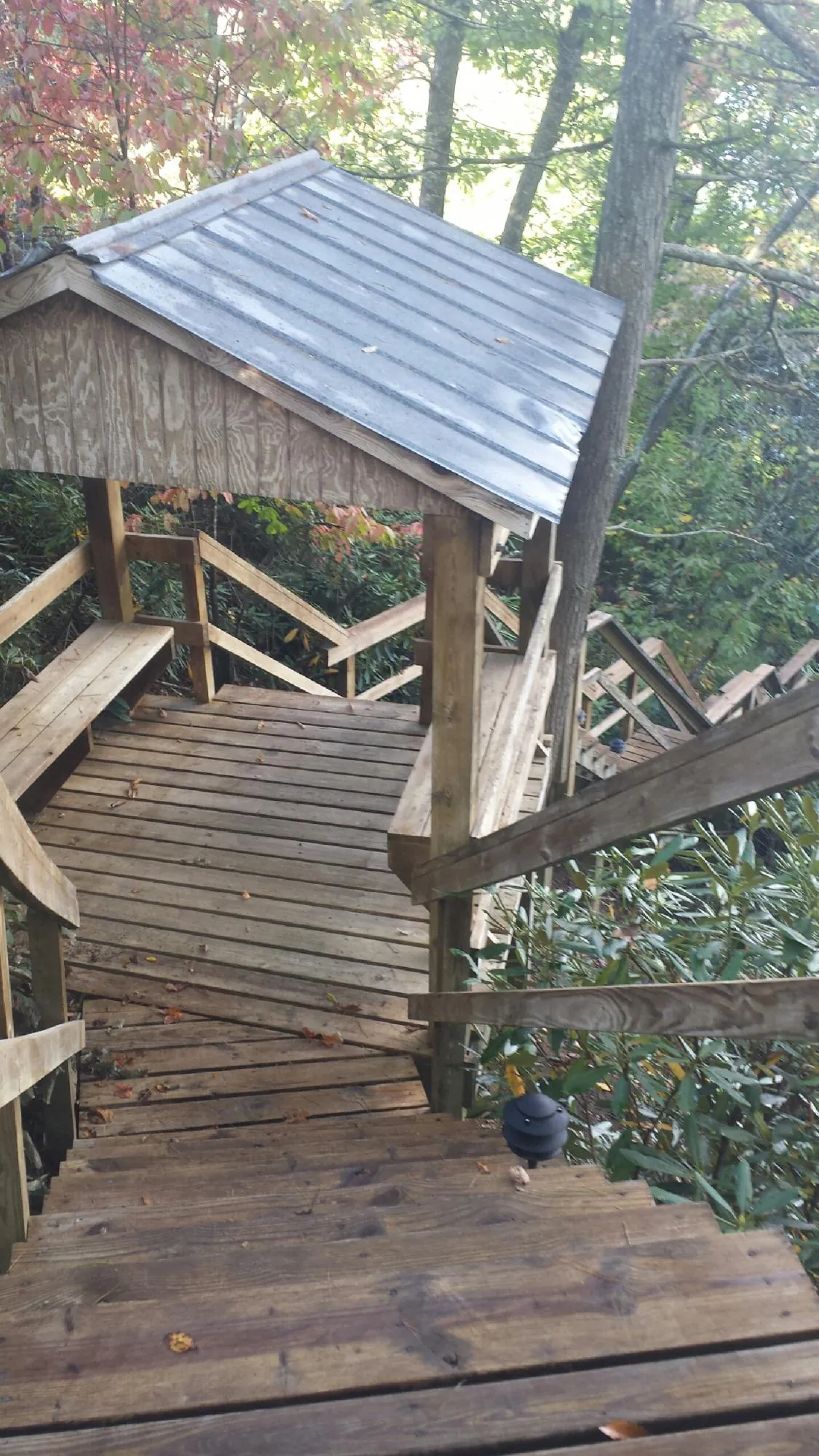 Metal roofed shelter over wooden steps on a wooded walkway in Santo Domingo Pueblo