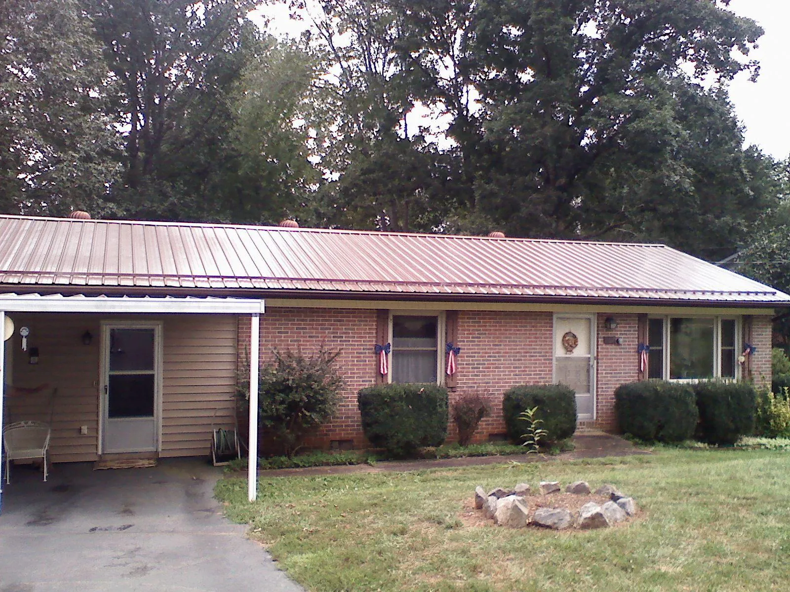 Bronze metal roof and carport on a brick ranch home — Roof Repair work by our crew in Santo Domingo Pueblo
